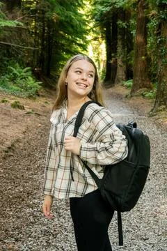 A Young Hiker Smiling Happily While Enjoying a Beautiful Forest Trail in Natures Stock Photos