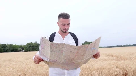 Young, hiking man with map looking for direction in autumn forest Stockbeeldmateriaal 77799237