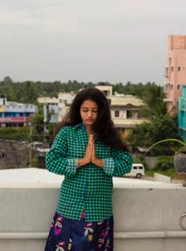 A young Hindu model standing in an open environment above the roof of the hou Stock Photos