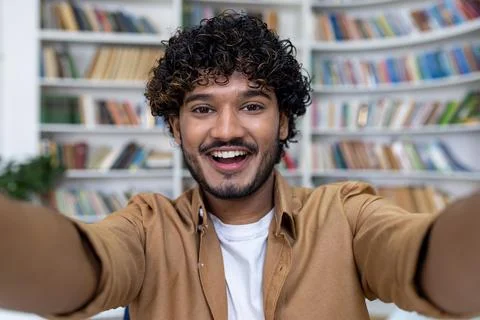 Young Hindu student programmer inside academic library taking selfie photo and Foto stock