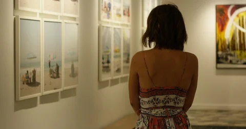 Young hip authentic woman browsing through art gallery Stock Footage