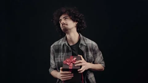 The young hipster is amazed by the content of the gift. He is pleasantly Video stock 155205677