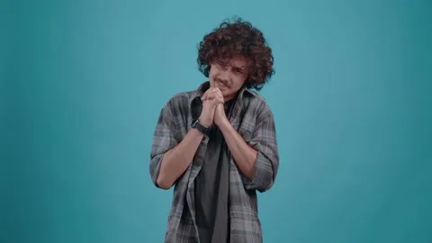 Young hipster asks for help praying with his hands together in the studio on a Video stock 152086809