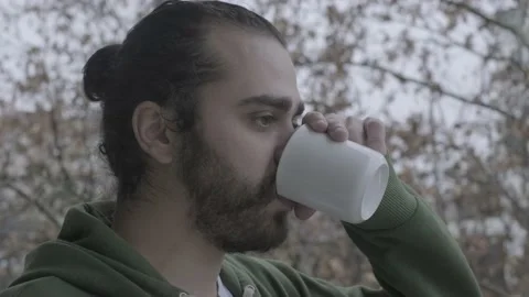 Young hipster drinking coffee in the snow Stock Footage 146891925