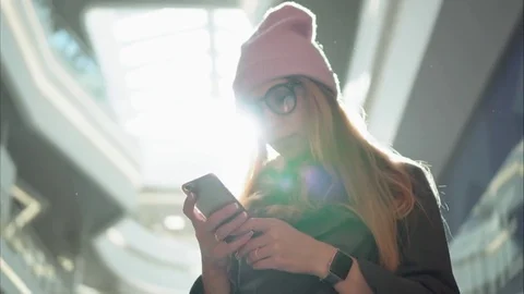 A young hipster female using app on the smartphone in the big mall Stock Footage 80734966