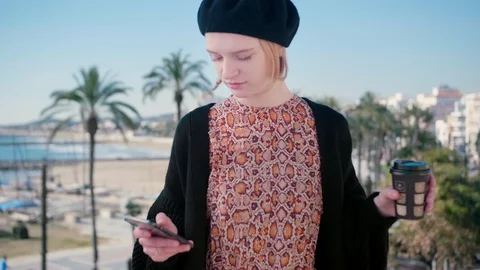 Young hipster lady with coffee making selfie on phone holidays sunny sea town Stock Footage 105608050