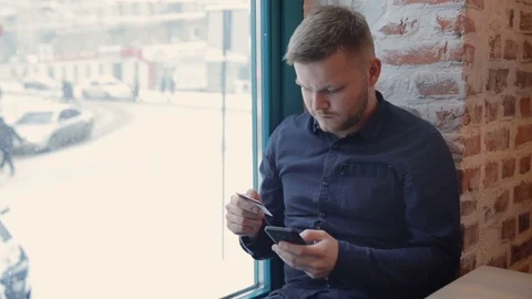 Young hipster make a purchase using an online application and a bank card on 스톡 동영상 93095784