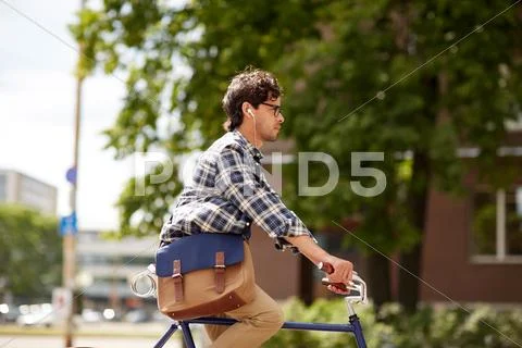 Young hipster man with bag riding fixed gear bike Stock Photos