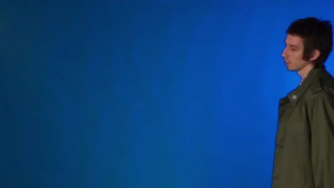 Young hipster man having fun and dancing in front of camera on blue background Stock Footage 132894071