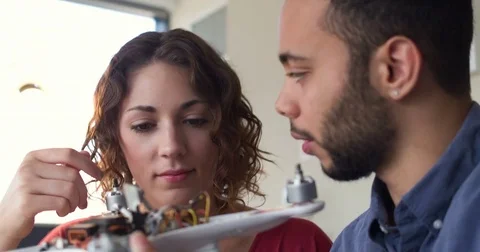Young Hipster Software Engineers Wiring A Robot In Their Startup Co-Working Stock Footage 82675068