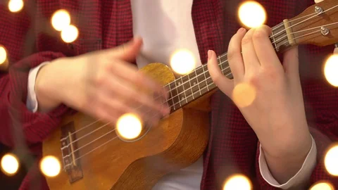 Young Hipster Woman Playing Ukulele Guitar. A woman reads a song text on a Stock Footage