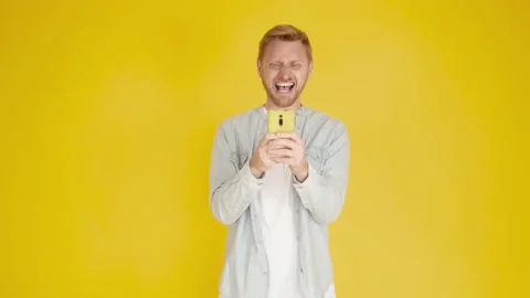 Young hispanic american man using mobile phone over isolated yellow background Stock Footage 189279789