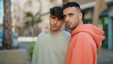 Young hispanic couple hugging each other standing with serious expression at  Video stock 171043343