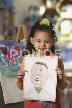 Young Hispanic girl holding artwork Stock Photos