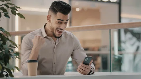 Young hispanic man amazed receiving sms message good news indian happy guy Stock Footage 170732917