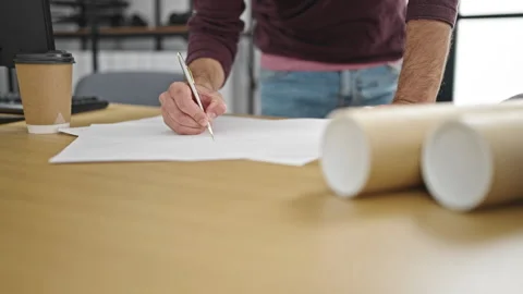Young hispanic man architect drawing house plans at street Stock Footage 241143654