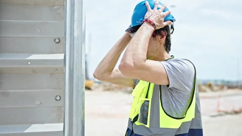 Young hispanic man architect stressed hitting head on wall at construction .. Stock Footage 247384908