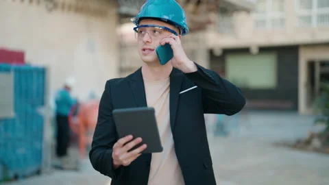 Young hispanic man architect talking on the smartphone using touchpad at stre Stock Footage 172054043