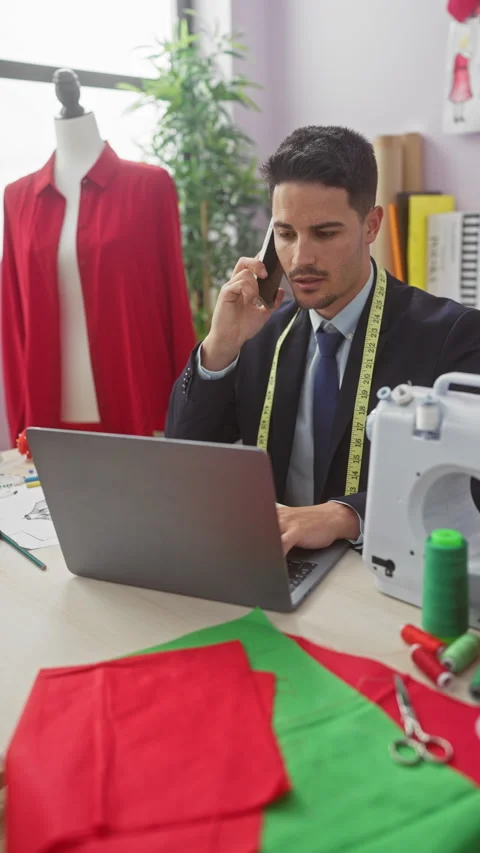 A young hispanic man with a beard uses a laptop and talks on the phone in a.. Stock Footage 278519676
