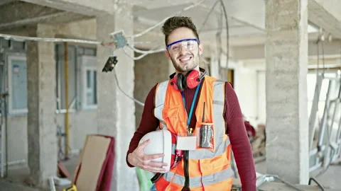 Young hispanic man builder smiling confident holding hardhat at constructio.. 스톡 동영상 245043992
