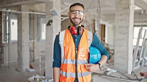 Young hispanic man builder smiling confident holding hardhat at constructio.. 스톡 동영상 247906522