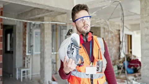 Young hispanic man builder tired using hardhat as a hand fan at constructio.. 스톡 동영상 245044072