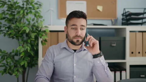 Young hispanic man business worker talking on the smartphone working at offic Video stock 180483660