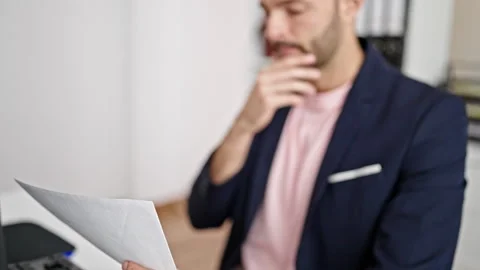 Young hispanic man business worker using computer reading document at office Stock Footage 245038573