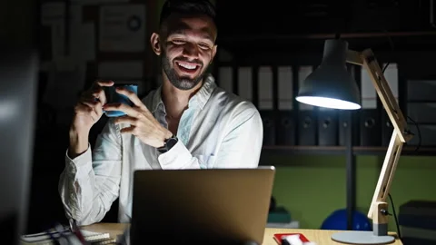 Young hispanic man business worker using laptop drinking coffee at the office Stock Footage 247382307