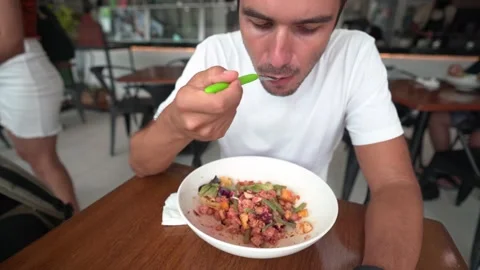 Young hispanic man with cap eats salad in a restaurant - healthy lifestyle Stock Footage 164531087