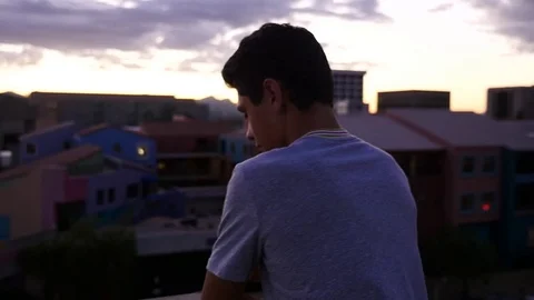 A young Hispanic man at a city viewpoint Видео 80117090