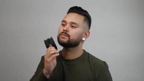 Young Hispanic Man Combing Dark Beard Stock Footage 173346959