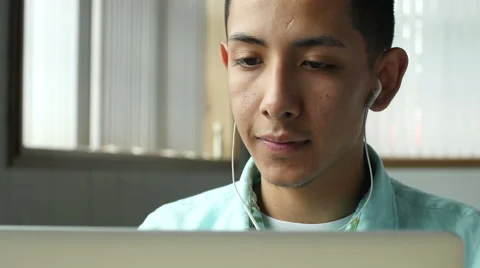 Young hispanic man on computer with headphones Stock Footage 49661150