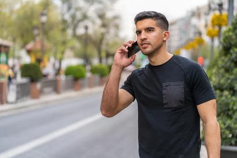 Young hispanic man with a dark complexion talking with the smartphone Stock Photos