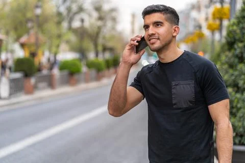 Young hispanic man with a dark complexion talking with the smartphone Stock Photos