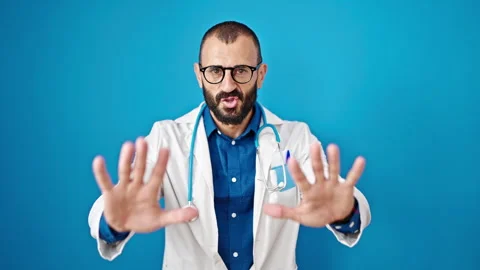 Young hispanic man doctor doing calm gesture with hands over isolated blue .. Stock Footage 245020826