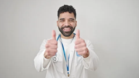 Young hispanic man doctor doing thumbs up over isolated white background Video stock 245047212