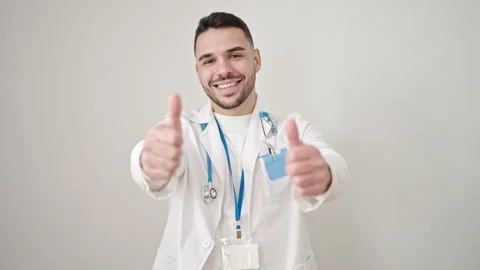Young hispanic man doctor doing thumbs up over isolated white background Video stock 246134272
