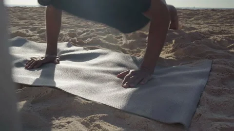 Young hispanic man does pushups on his yogamat at the beach Stock Footage 172441730