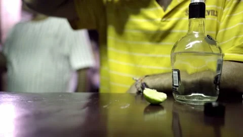 A young Hispanic man is drinking tequila on a bar counter Stock Footage 221786446