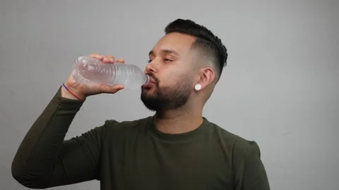 Young Hispanic Man Drinking Water from Plastic Bottle Stock Footage 173346958