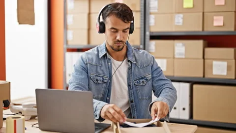 Young hispanic man ecommerce business worker packing clothes on cardboard b.. Video stock 246127342