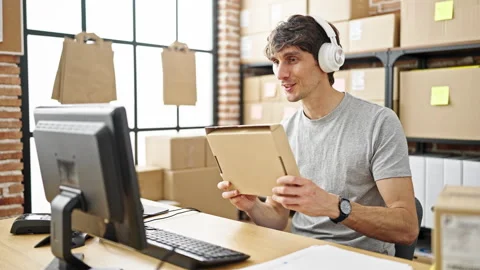 Young hispanic man ecommerce business worker having video call holding pack.. Video stock 247384976