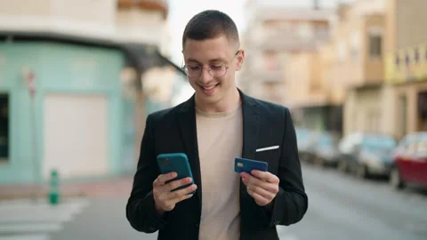Young hispanic man executive using smartphone and credit card at street Stock Footage 171040833