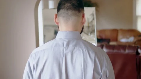 Young hispanic man getting ready in front of mirror raises arms to celebrate Stock Footage 84485592