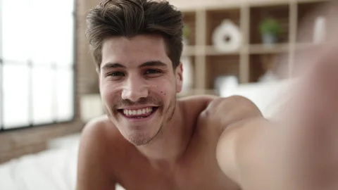 Young hispanic man having video call lying on bed at bedroom Video stock 233417150