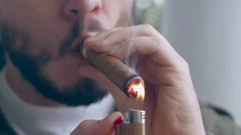 Young hispanic man lighting end of cigar in his mouth Stock Footage 84491018