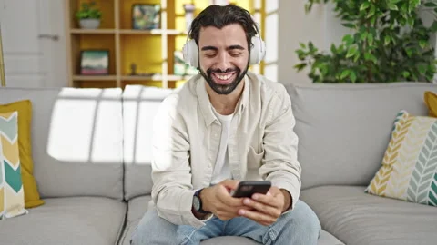 Young hispanic man listening to music dancing at home Video stock 247378341