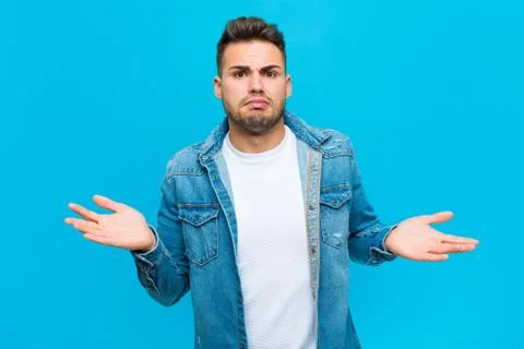 Young hispanic man looking puzzled, confused and stressed, wondering between  Foto stock
