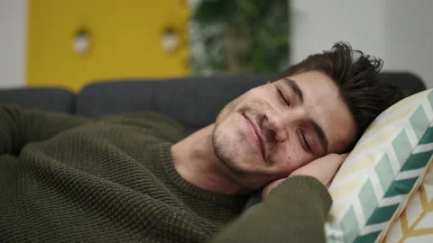 Young hispanic man lying on sofa sleeping at home Stock Footage 233416251